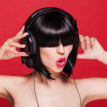 girl black headphones on ears brunette red background 
